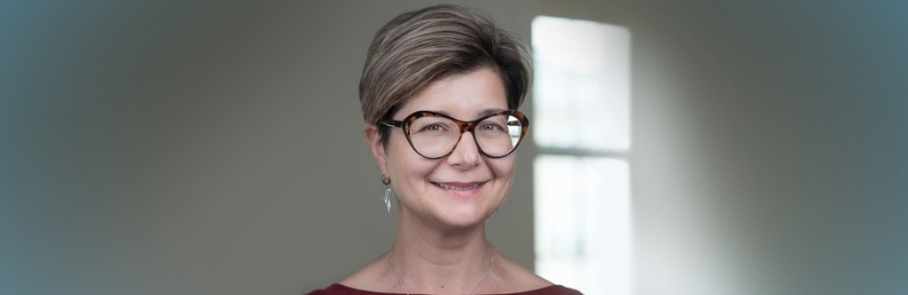 Head shot of Nicole A. Theodosiou, Ph.D. in glasses by window 