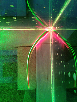 A lamprey swimming in the corner of a water tank at MBL while illuminated by green and red laser sheets. Reflections in the corner of the water tank give the appearance of multiple lamprey eels. Credit: Sean P. Colin