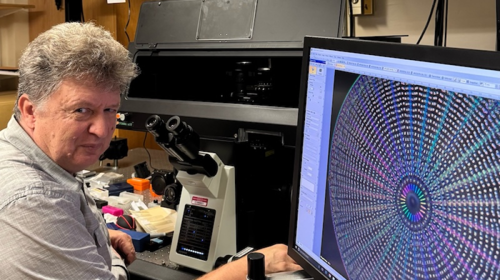A man seated at a microscope