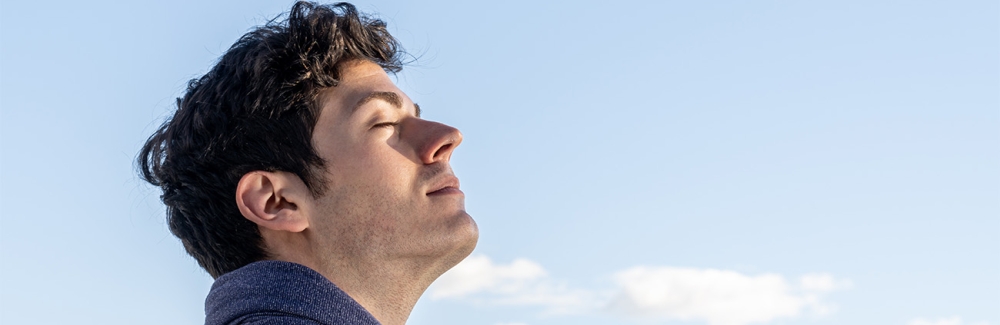 boy with eyes closed and sky