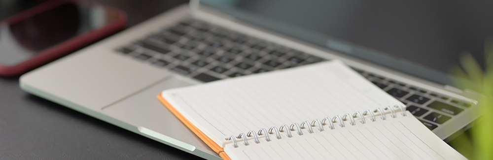 Laptop and notebook on a desk