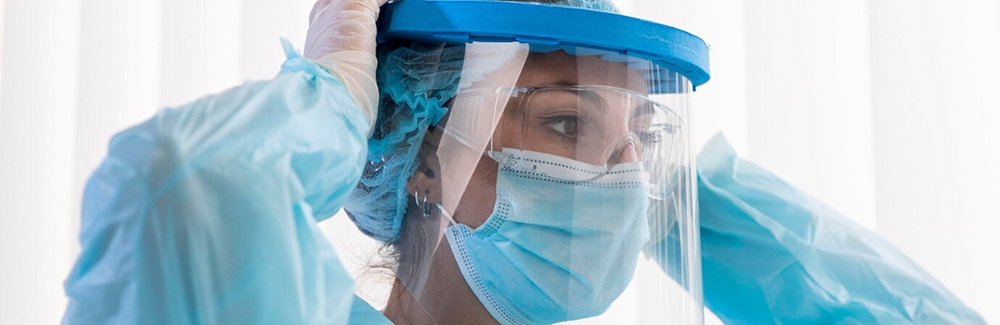 Woman putting on face shield