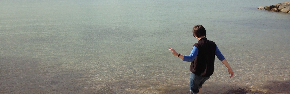 Woman putting toe in ocean