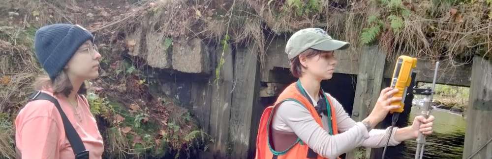 two students measure water levels during the 2023 Semester in Environmental Science at the MBL