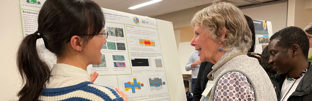 two people stand infront of a poster at the 2024 Plum Island Ecosystems LTER annual meeting at the MBL. Credit: Diana Kenney