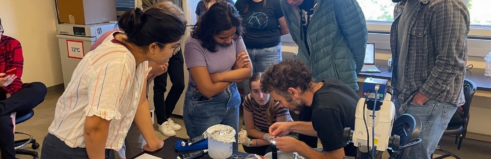 students in a group looking at a specimen