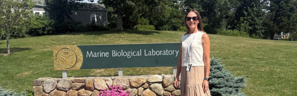 Shari Eberts stands in front of the MBL Sign. 