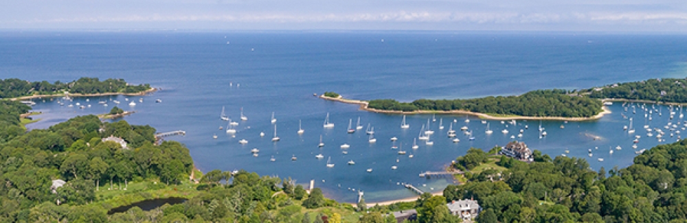Aerial view of The Knob and Quissett Harbor in Woods Hole, with greater Buzzards Bay in the distance.