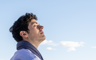 boy with eyes closed and sky