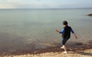 Woman putting toe in ocean