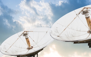 three satellite dishes pointed towards sky