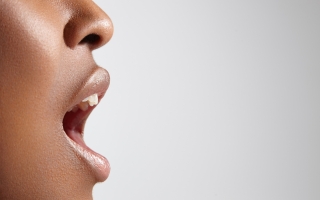 Black woman in profile with open mouth