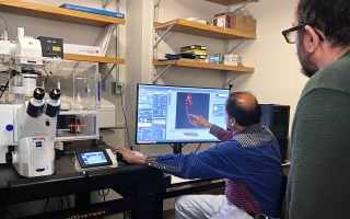Nipam Patel, director of the Marine Biological Laboratory, demonstrated a confocal microscope to a small group of fellows. The microscope can capture a three-dimensional object through two-dimensional scans at different depths. Researchers then run a software program to construct three-dimensional models of the sample. Credit: Anna Kass | Knight Science Journalism Program