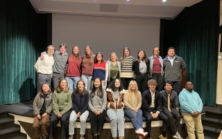 2024 SES Students sit on the stage at Cornelia Clapp Auditorium after their independent student symposium. 