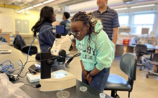 A student from Colby College peers into a microscope in Loeb Laboratory. Credit: Alex Megerle