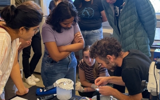 students in a group looking at a specimen