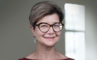 Head shot of Nicole A. Theodosiou, Ph.D. in glasses by window 