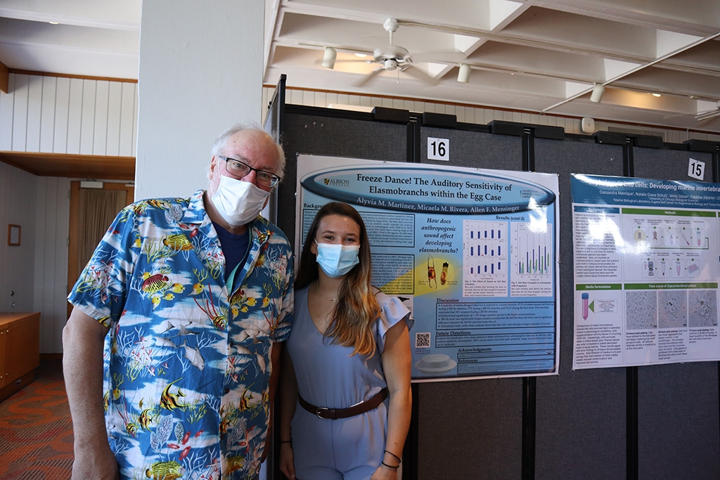 Alyvia Martinez and Allen Mensinger (left) in front of presentations