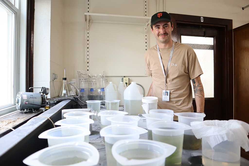 Whitman Fellow Vincent Boudreau stands in his lab with thousands of Stentors from Morse Pond.