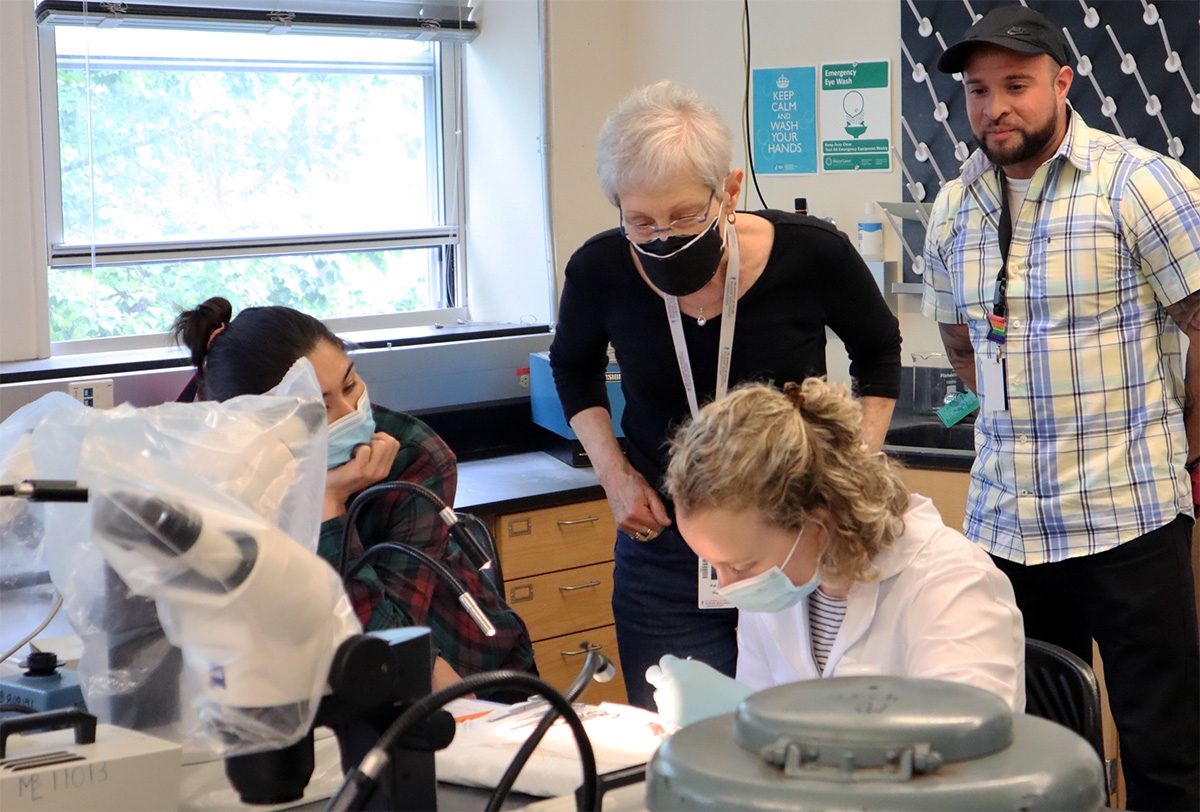 Hunt looks over the shoulder of an ECHO student working in the lab.