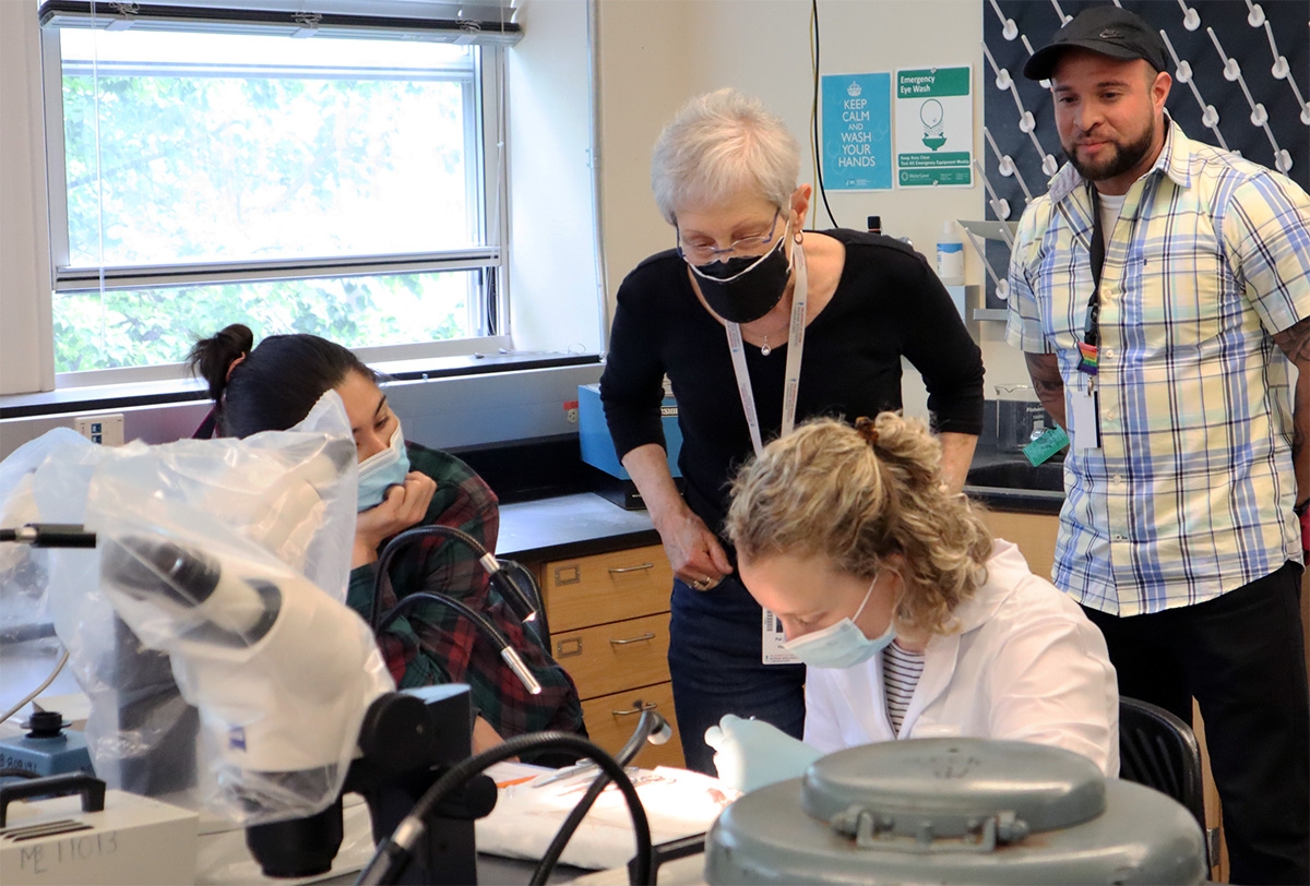 Hunt looks over the shoulder of an ECHO student working in the lab. 