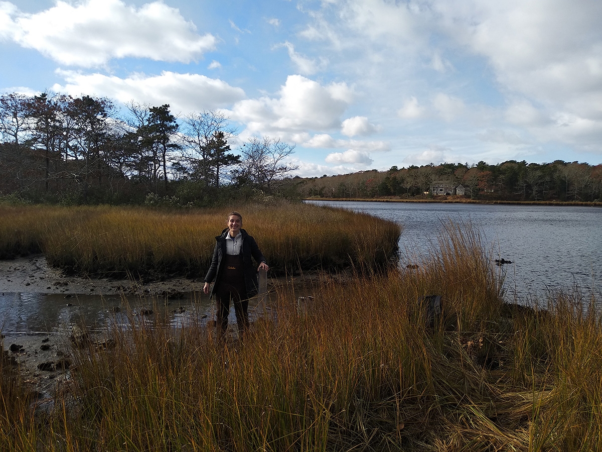 Semester in Environmental Science (SES) Student Claire McGuire prepares to take a sediment core sample in Waquoit Bay, Mass.