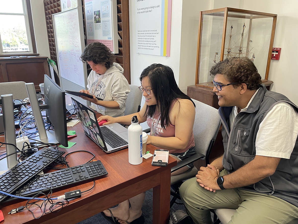 Shalin Mehta of Chan Zuckerberg Biohub, right, co-director of Deep Learning@MBL, assists student Gloria Lau of University of Illinois, Urbana-Champaign. At left is course teaching assistant Larissa Heinrich of HHMI Janelia.