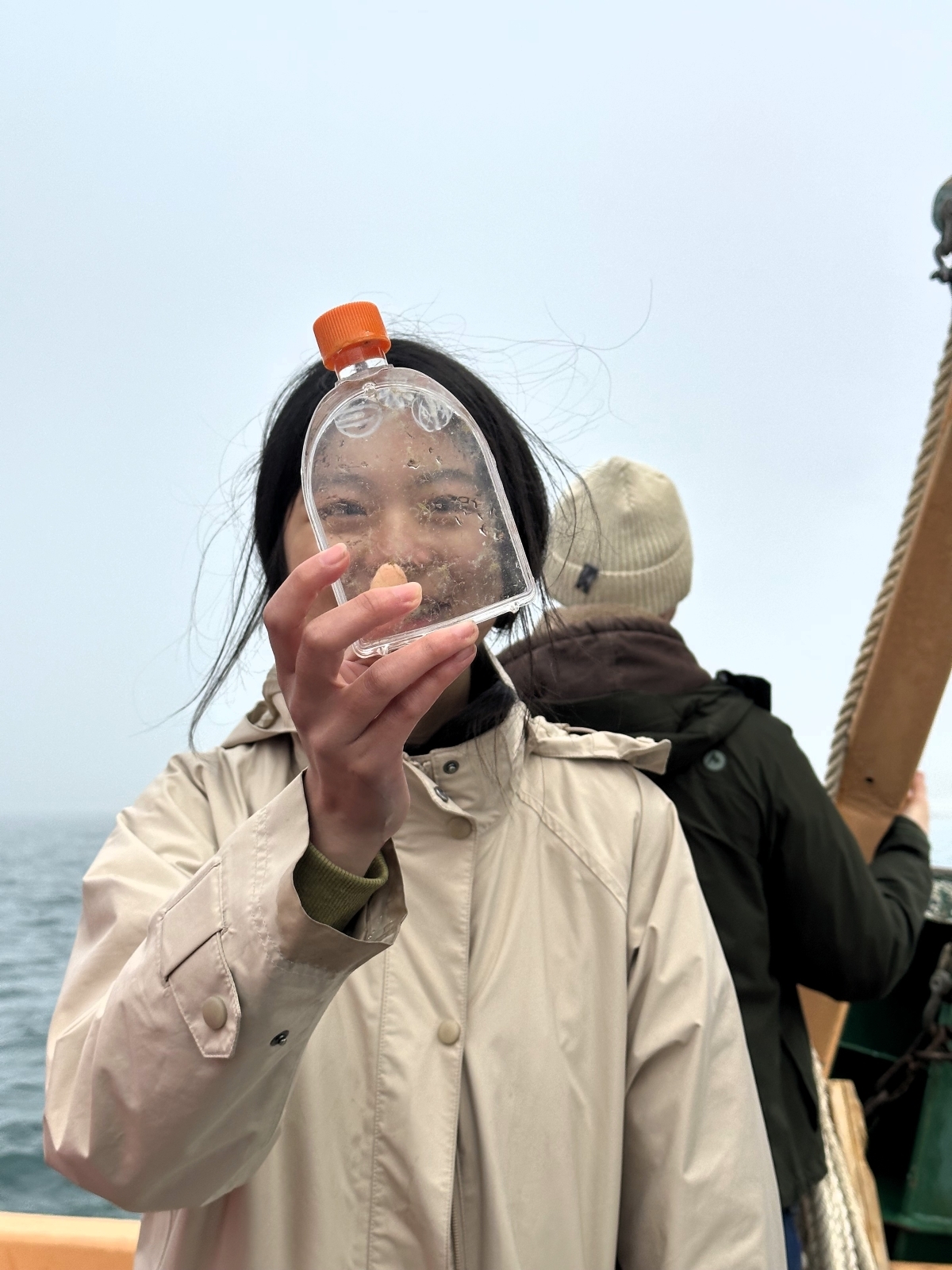 Student looks through bottle with comb jellies