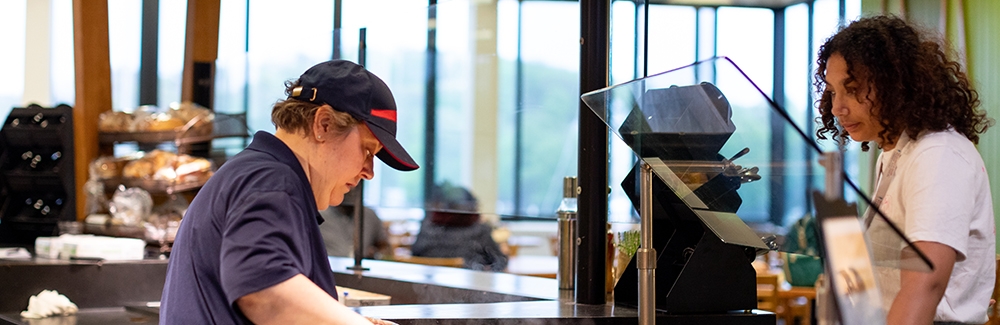 A person in Swope Cafe serving someone.