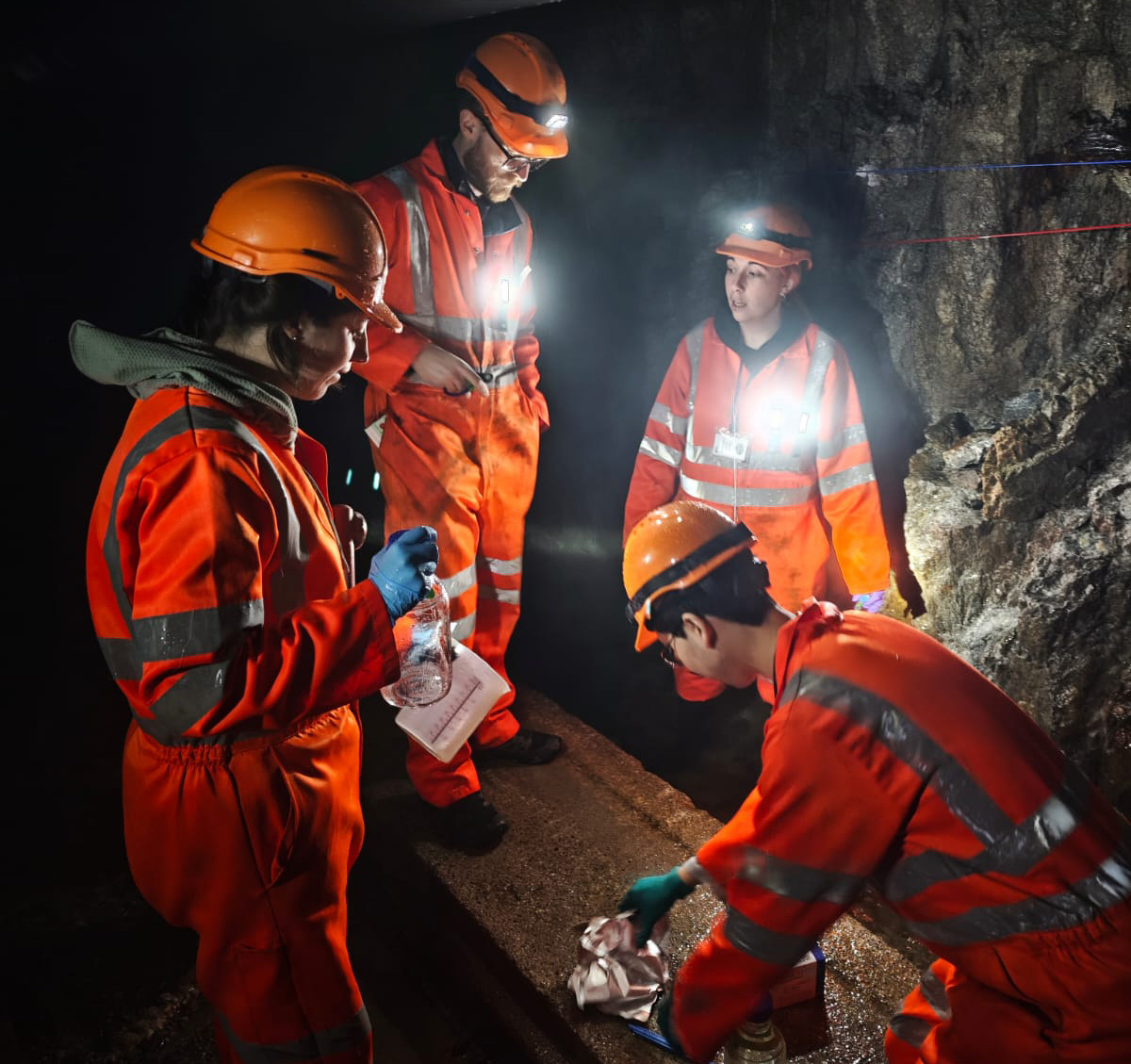 Four scientists sampling fracture fluids deep beneath the Gotthard massif in the Swiss Alps. 