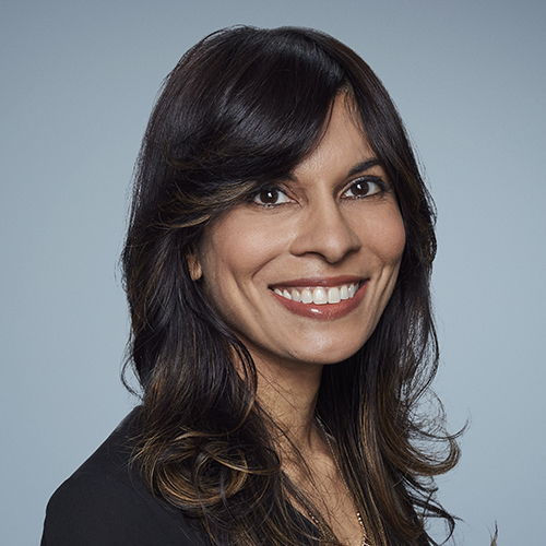 Smiling woman with long dark hair wearing a dark shirt.