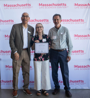 Three people smile for an awards photo