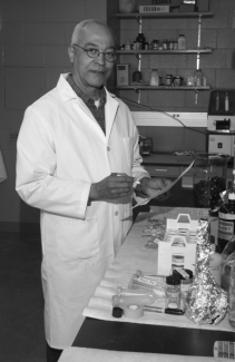 Man in lab coat holding pen and paper.