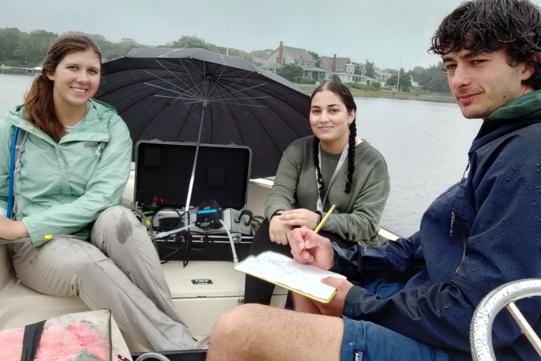 three students do field work in the rain