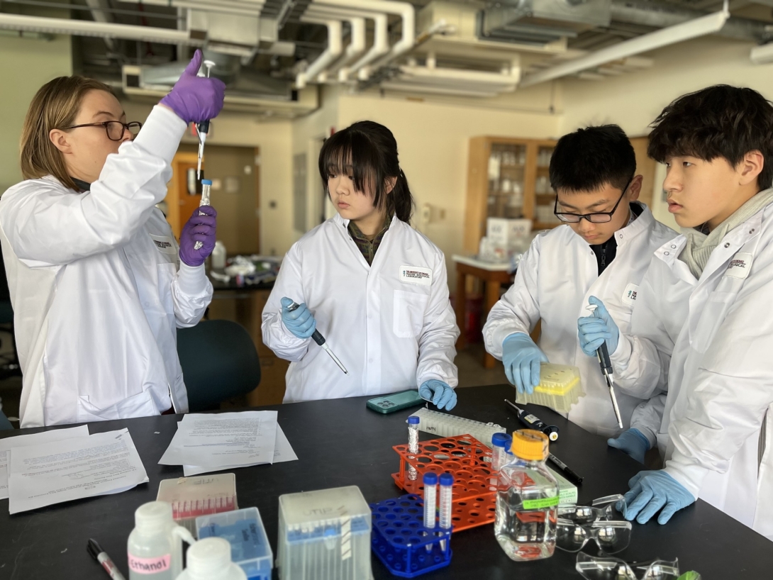 Research assistant Hannah Vanderscheuren assists WLSA Shanghai Academy students in preparing DNA for quantification.