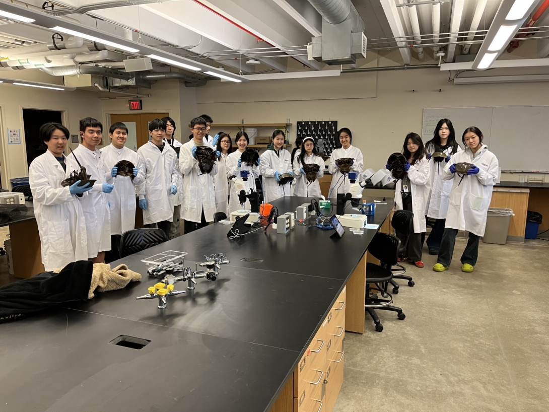 Students from Shanghai Star-River Bilingual School hold up horseshoe crabs in Loeb Laboratory