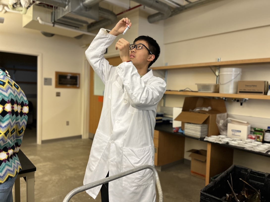 A student from Shanghai Star-River Bilingual School examines a vial of hemolymph from a horseshoe crab in Loeb Laboratory